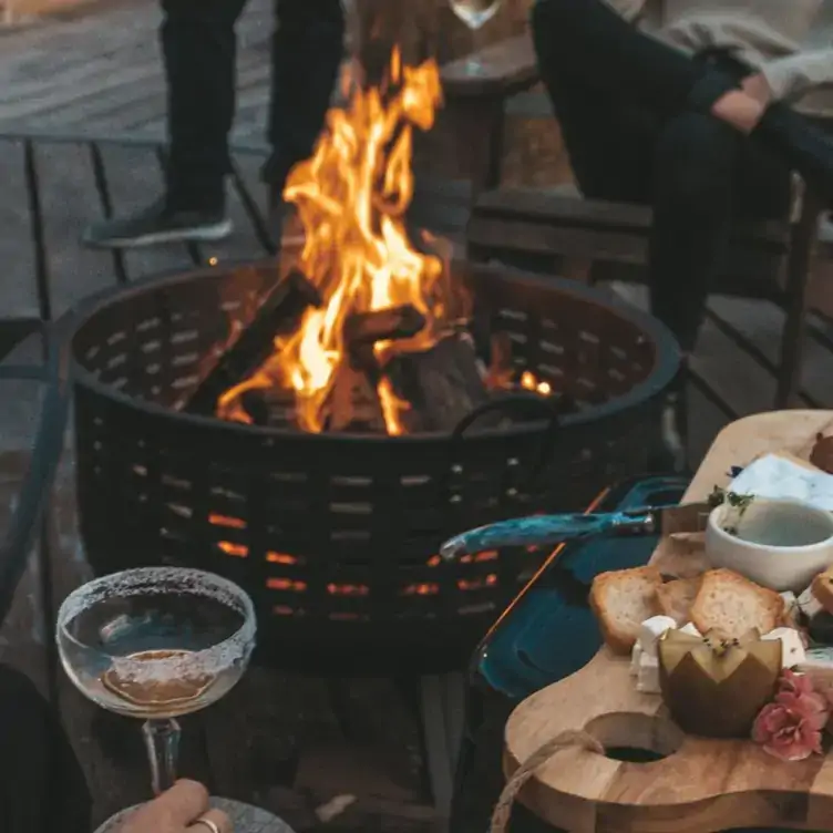 A board of charcuterie sits in front of a wood fire at Robina Pavilion - The Brasserie, one of the best family restaurants on the Gold Coast.