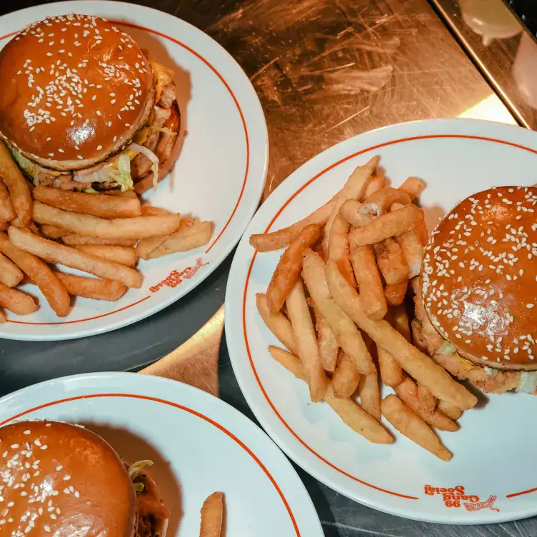 Three plates of burgers with chips served at 99 Gang Social, one of the best family restaurants in Adelaide.