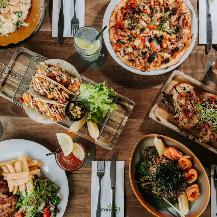 Multiple dishes, including pizza, tacos and bruschetta, served at Eatons Hill, one of the best family restaurants in Brisbane.