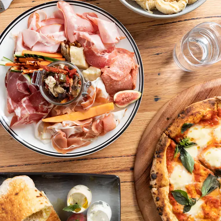 A table of antipasti and pizzas at Ms Peacock, one of the best family restaurants in Melbourne.