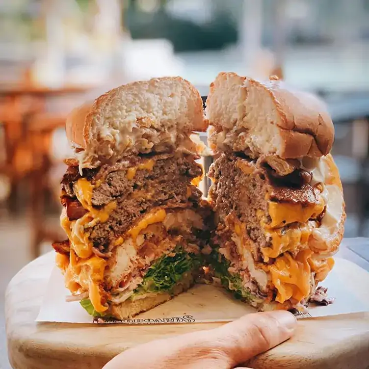 A burger with multiple beef patties, cut in half and served at Longboards Laidback Eatery & Bar.