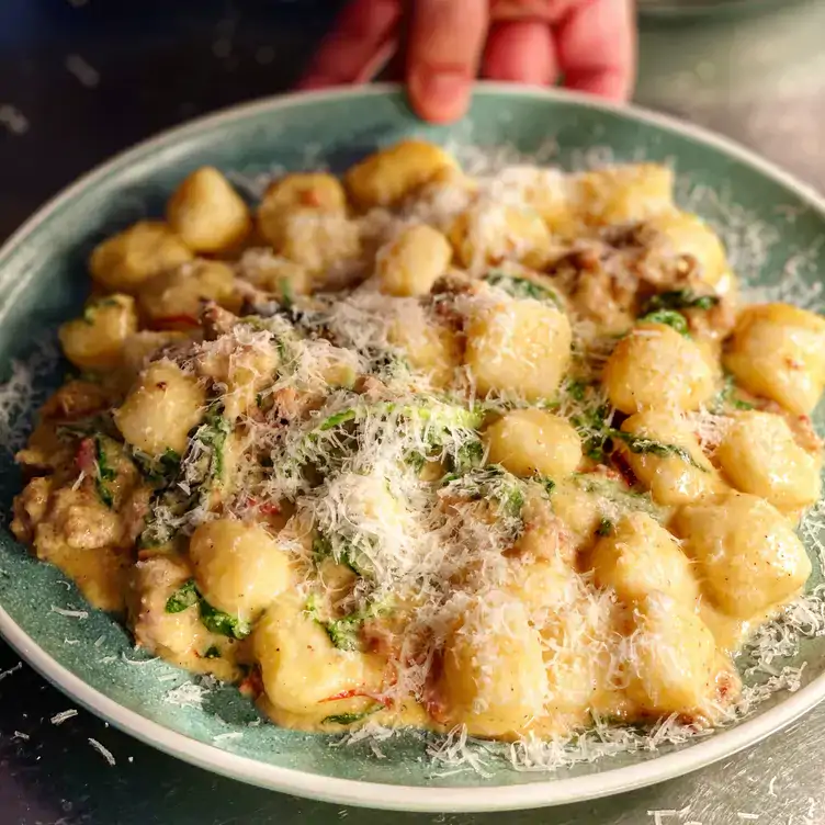 A dish of gnocchi in a creamy sauce topped with herbs and cheese served at Hello Neighbour Artusi by Night, one of the best brunch spots in Adelaide.