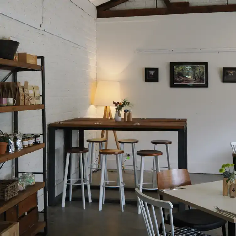 Kitchen Farm’s interior dining space showing the simple brown and white colour scheme and shelves with bags of coffee.