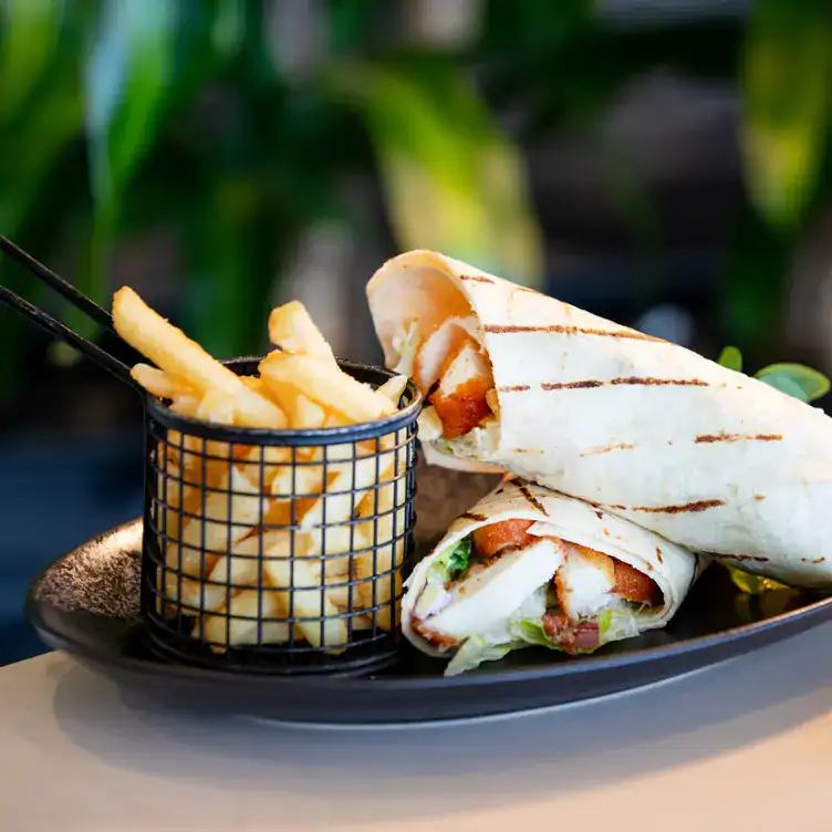 Chicken schnitzel wraps served alongside chips at Sails Restaurant, Redlands RSL, one of the best family restaurants in Brisbane.