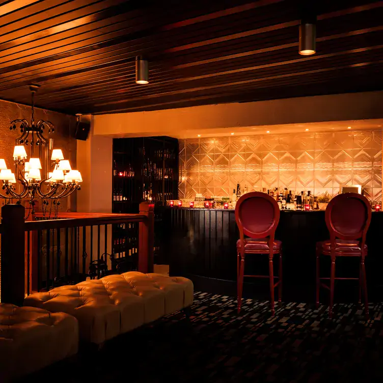 Two leather stools sit at a counter on the mezzanine level of Claire’s Kitchen, one of the best warm and cosy restaurants in Australia.