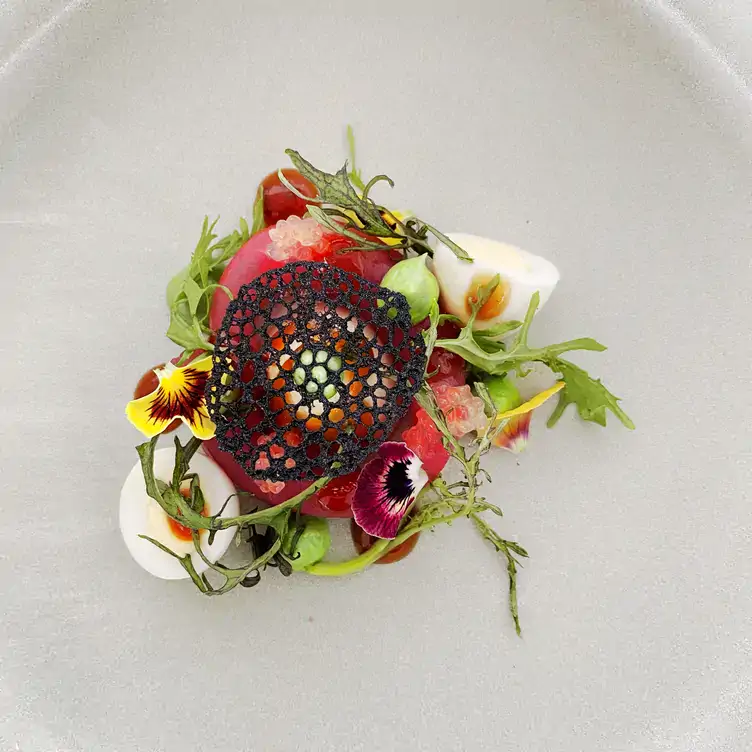 A detailed dish topped with flower petals served at The Wintergarden, one of the best warm and cosy restaurants in Australia.