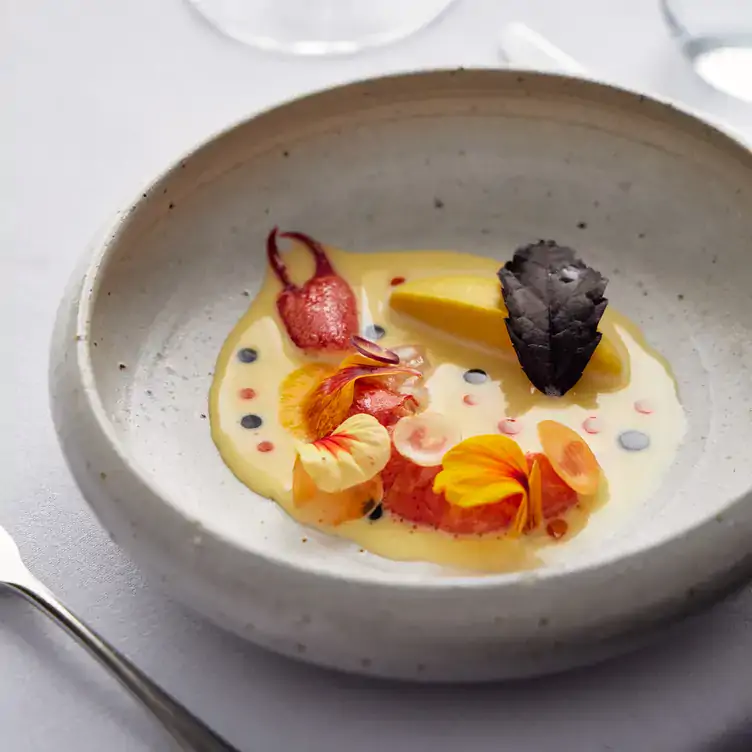 A seafood dish served in a smooth yellow sauce and garnished with petals at Hardy’s Verandah Restaurant.