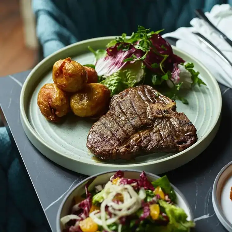 A dish of steak, salad and potatoes served at Blaq, one of the best warm and cosy restaurants in Australia.