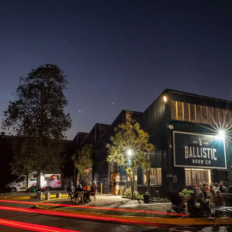 The exterior of Ballistic Beer, showing its outdoor seating, two storeys and black exterior walls with large windows.