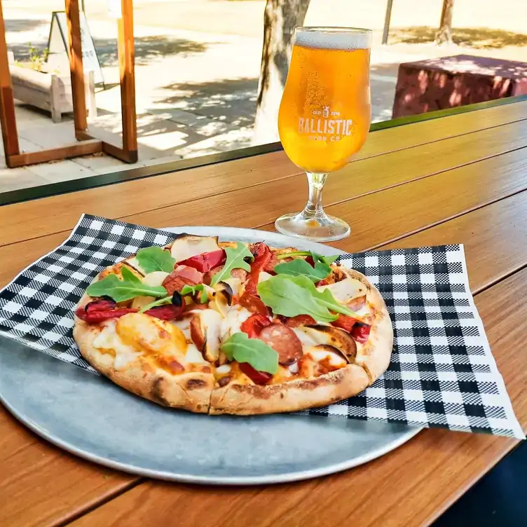 A pizza served alongside a glass of beer at Ballistic Beer, one of the best pubs in Brisbane.