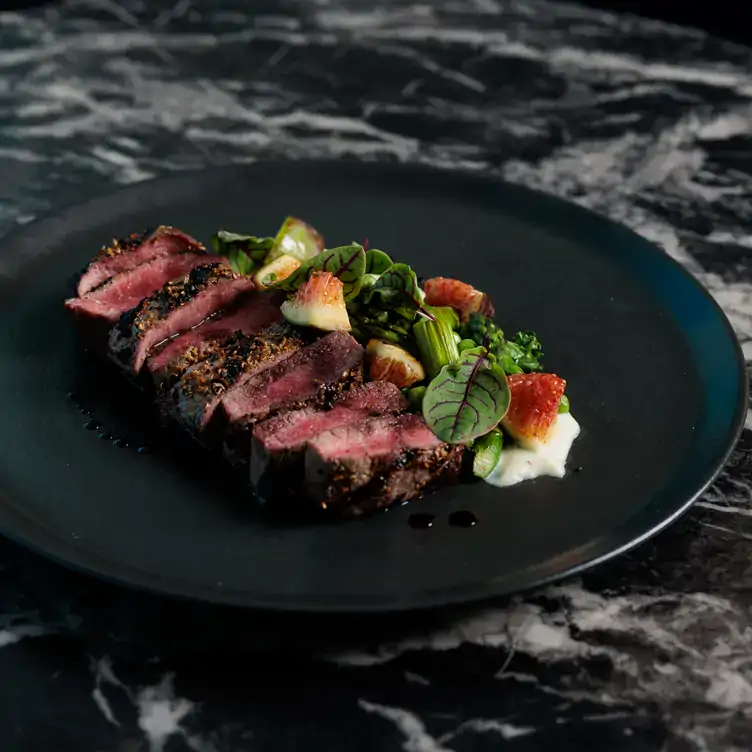 A plate of sliced steak served alongside a fig salad at Storehouse Subiaco, one of the best bars in Perth.