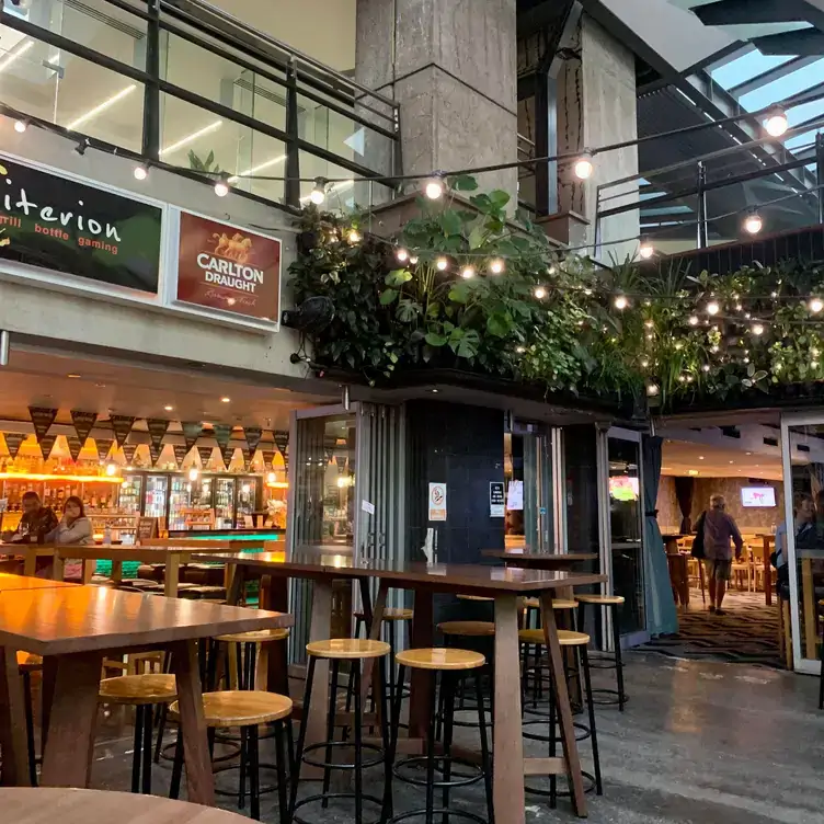 Outdoor seating at Criterion Tavern, one of the best pubs in Brisbane, with a view into the indoor area through the fully open doors.