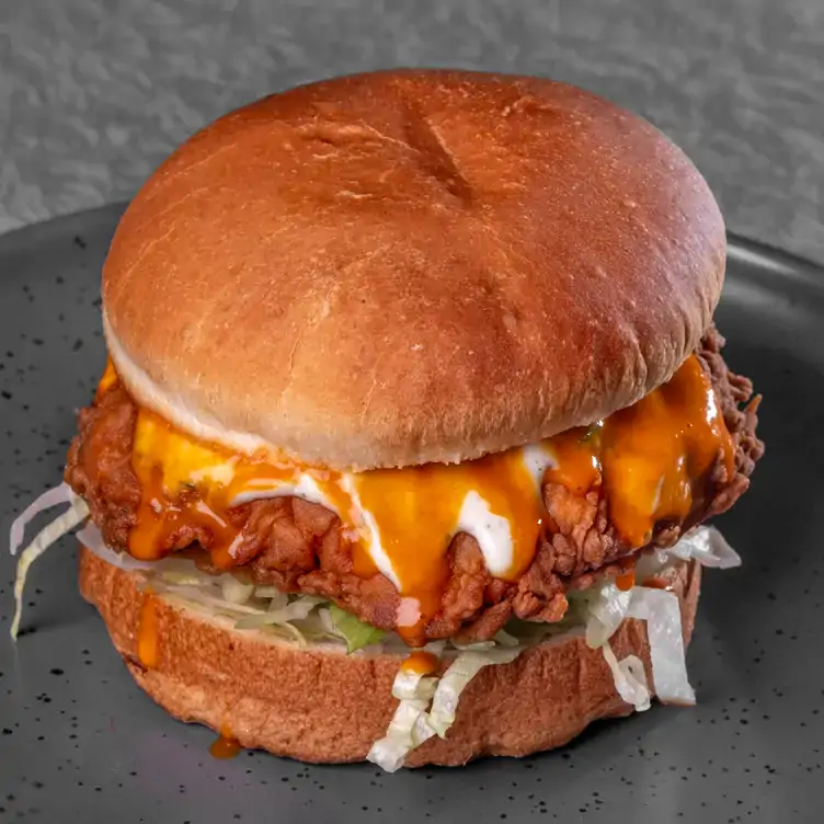 A fried ‘chicken’ burger topped with sauce served at Two-Bit Villains one of the best pubs in Adelaide.