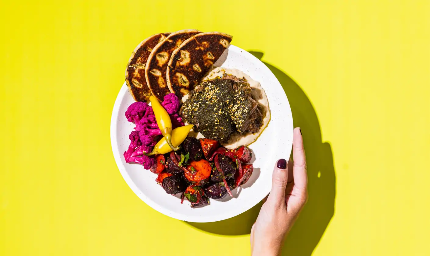 A plate of food from MOD Dining on a bright yellow background.