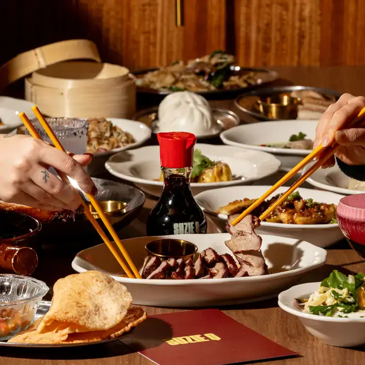 Two pairs of chopsticks tuck into Chinese-inspired dishes at Suzie Q, a new restaurant in Melbourne.