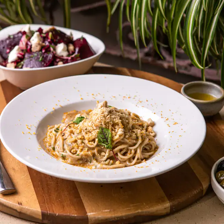 Dig into comforting bowls of handmade pasta at Olive and Angelo. Credit: Olive and Angelo A bowl of spaghetti in a creamy brown sauce on a wooden board at Olive and Angelo, one of Brisbane’s best Italian restaurants.